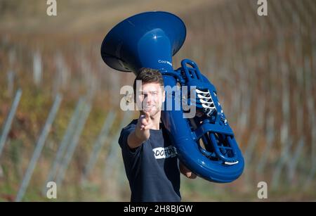 Brackenheim, Allemagne.23 novembre 2021.Micha, de Brackenheim, musicien portant le nom de scène 'Micha von der Rampe', tient son tuba bleu.Il a raccroché un emploi dans la banque pour sa musique.Au lieu de porter un costume, il vient maintenant dans un pantalon en cuir et apporte une bouffée d'air frais dans la scène pop avec son tuba bleu.Credit: Marijan Murat/dpa/Alamy Live News Banque D'Images