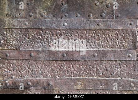 Détail de la bordure métallique de la porte médiévale.Texture du vieux métal avec des rivets et des planches rouillées Banque D'Images