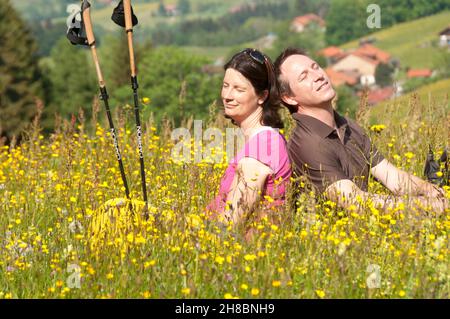 Les parents enceintes se détendent dans un pré de fleurs Banque D'Images