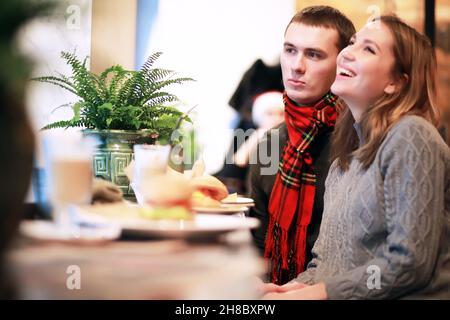 Heureux couple eating fast food burger et döner dans fast food cafe Banque D'Images