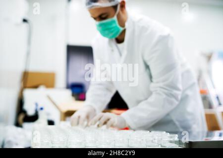 Technicien de pharmacie masculin.Homme travaillant avec des béchers de laboratoire et de la verrerie.Scientifique menant une expérience en laboratoire Banque D'Images