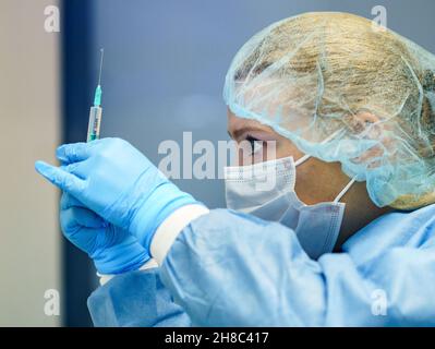 29 novembre 2021, Rhénanie-Palatinat, Mayence: Un membre du personnel rédige une seringue avec le vaccin de Biontech au début de la vaccination de rappel COVID-19 au centre de vaccination de police.La police de Rhénanie-Palatinat avait déjà mis en place un total de quatre centres de vaccination de février à juillet 2021 pour effectuer la vaccination interne de la police Corona.Photo: Frank Rumpenhorst/dpa Banque D'Images