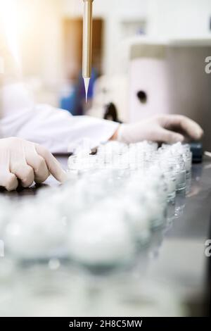 Mains du technicien de la pharmacie.Homme travaillant avec des béchers de laboratoire et de la verrerie.Scientifique menant une expérience en laboratoire Banque D'Images