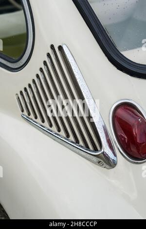 Gros plan sur le détail de la carrosserie et le feu stop sur une microvoiture japonaise Subaru 360 Deluxe blanche classique de la ville Banque D'Images