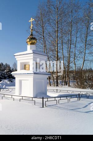 Chapelle blancheur avec dôme d'or(en) et croix sur le bois de fond. Paysage avec pin et bouleau à la durée de l'hiver Banque D'Images