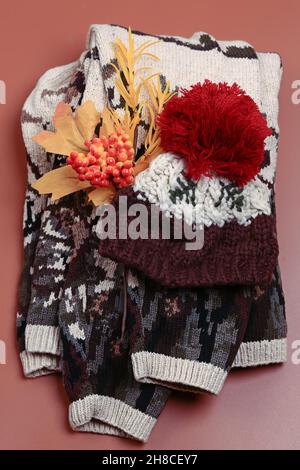ensemble de vêtements chauds d'automne sur fond beige, vue du dessus.Pull en maille et bonnet en laine.Style plat et place pour le texte. Banque D'Images
