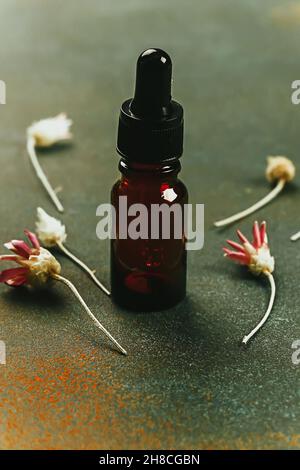 Laboratoire cosmétique abstrait.Bouteilles de verre ambré foncé sur fond vert podium.Cosmétiques naturels pour les soins, homéopathie. Banque D'Images