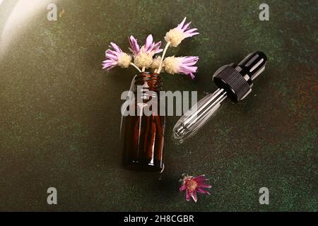 Laboratoire cosmétique abstrait.Bouteilles de verre ambré foncé sur fond vert podium.Cosmétiques naturels pour les soins, homéopathie. Banque D'Images