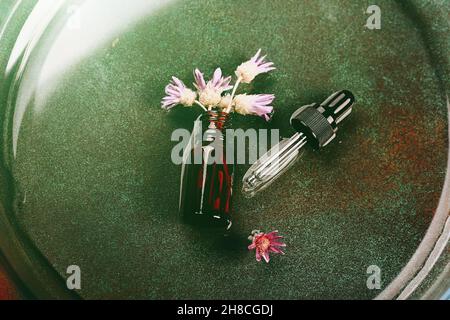 Laboratoire cosmétique abstrait.Bouteilles de verre ambré foncé sur fond vert podium.Cosmétiques naturels pour les soins, homéopathie. Banque D'Images