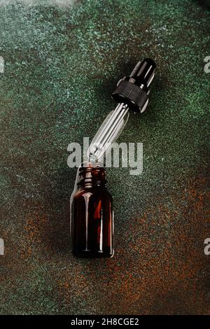 Laboratoire cosmétique abstrait.Bouteilles de verre ambré foncé sur fond vert podium.Cosmétiques naturels pour les soins, homéopathie. Banque D'Images