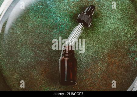 Laboratoire cosmétique abstrait.Bouteilles de verre ambré foncé sur fond vert podium.Cosmétiques naturels pour les soins, homéopathie. Banque D'Images