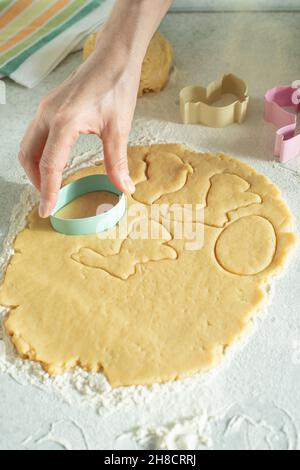 Modèle femelle de pâte coupée avec emporte-pièce sur la table de cuisine Banque D'Images