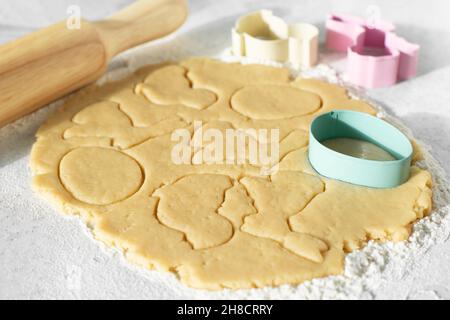 Pâte avec emporte-pièces et broche roulante sur la table de cuisine Banque D'Images