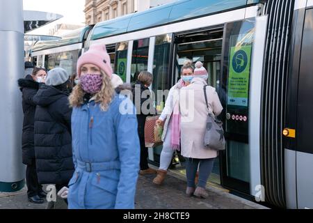 Les gens défont un tramway à Nottingham, la ville où l'un des deux cas de la variante Omicron de Covid-19 a été identifié la semaine dernière. Banque D'Images