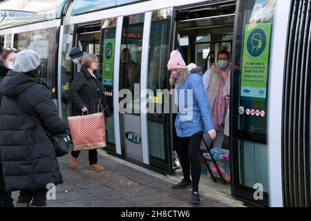 Les gens défont un tramway à Nottingham, la ville où l'un des deux cas de la variante Omicron de Covid-19 a été identifié la semaine dernière. Banque D'Images