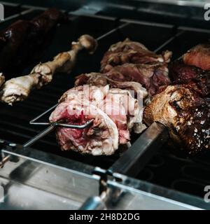 Différentes viandes sont cuites sur des brochettes sur le gril électrique.Équipement de cuisine dans le restaurant. Banque D'Images