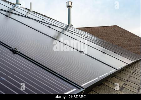 Accent sélectif sur les panneaux solaires installés sur un toit de bardeaux en asphalte résidentiel Banque D'Images