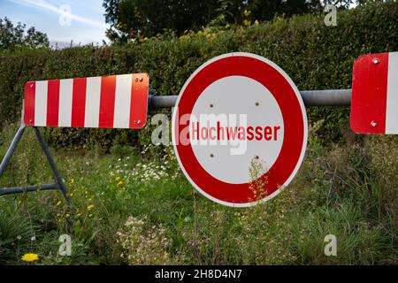 Panneau de rue allemand rouge et blanc 'Hochwasser' qui signifie 'marée haute'. Banque D'Images