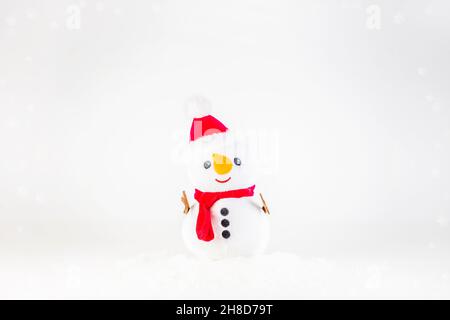 Jouet doux générique de bonhomme de neige avec neige sur fond blanc Banque D'Images