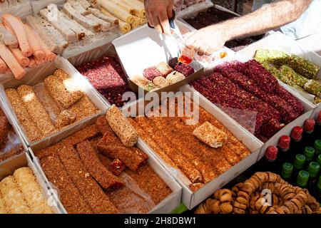 Assortiment de délices turcs ou de sweets lokum sur le marché de bazar turc.Négociant faisant boîte avec des rouleaux lokum pour le touriste. Banque D'Images