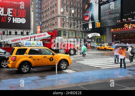 NEW YORK, USA - 10 juin 2013 : les taxis jaunes dur sous la pluie à Times Square, New York City. Times Square possède plus de 39 millions de visiteurs annuels. C'est un im Banque D'Images