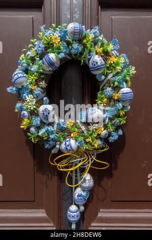 Une couronne fleurie ornée de boules en porcelaine bleue et blanche, accrochée sur une porte en bois marron dans la Golden Lane médiévale du château de Prague Banque D'Images