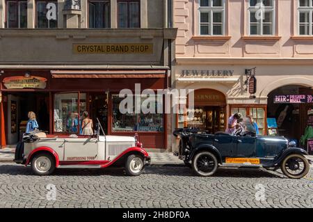 Deux voitures de tourisme classiques vous attendent dans la rue Mostecká de Malá Strana Banque D'Images