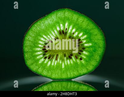 Tranche de kiwi gros plan sur fond sombre.Horizontal. Espace pour le texte Banque D'Images
