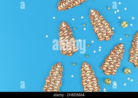 Biscuits en forme d'arbres de Noël avec asperges de sucre sur fond bleu Banque D'Images