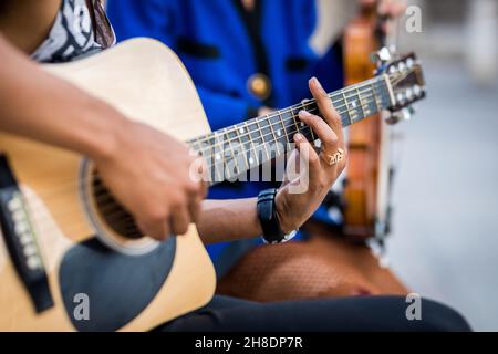 Détail du guitariste latin jouant de la guitare à côté de la violoniste féminine Banque D'Images