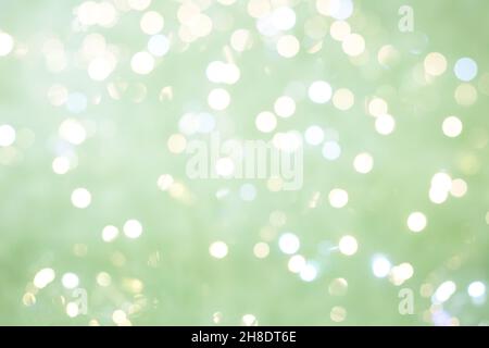 Lumières et ampoules défocacées sur fond vert argenté.Concept d'arrière-plan festif.Copier l'espace Banque D'Images
