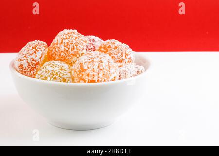 Beaucoup de marmelade colorée, avec saveur de fruit, dans une assiette blanche, sur fond blanc rouge.Nourriture pour le diabète.Bonbons sans sucre.Copier l'espace Banque D'Images