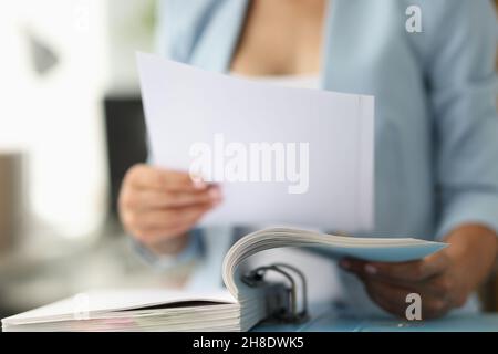 Femme d'affaires en costume regardant des documents de la fermeture de dossier Banque D'Images