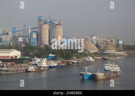 Navires plus légers pleins de matières premières ancrées pour le déchargement sur la rivière Shitalakshya près des usines de ciment de Narayanganj, au Bangladesh. Banque D'Images