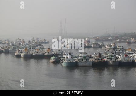 Navires plus légers pleins de matières premières ancrées pour le déchargement sur la rivière Shitalakshya près des usines de ciment de Narayanganj, au Bangladesh. Banque D'Images