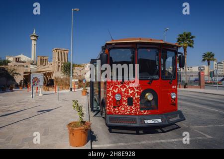 Dubaï, Émirats arabes Unis 17 février 2020 : anciens bâtiments de Dubaï et rue arabe.Quartier historique d'Al Fahidi, Al Bastakiya. Beau bus rouge touristique à l'arrêt contre de la mosquée Banque D'Images