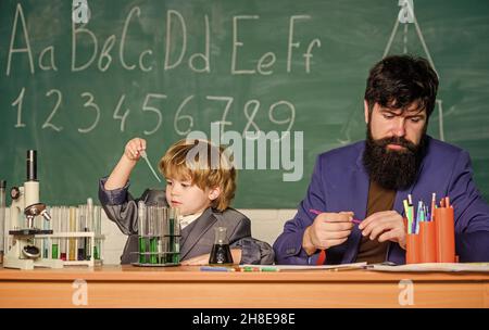 Jouez avec des liquides.Exemple personnel inspirant.Connaissances scolaires.Professeur et laboratoire de chimie de garçon.Journée de la connaissance vacances de septembre.Niveau de base Banque D'Images