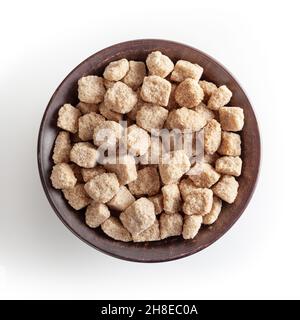 Cubes de sucre de canne à sourcils dans un bol en céramique isolé sur fond blanc avec passe-cheveux Banque D'Images