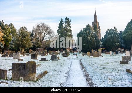 Vue sur le cimetière de l'église St Michael's à Tilehurst Reading en hiver avec une couverture de neige légère. Banque D'Images