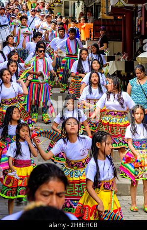 Les jeunes Péruviens dansent dans la rue principale à travers Aguas Calientes pendant le Festival de la procession des croix Banque D'Images