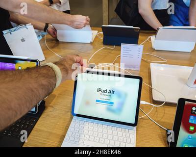 ipad Air dans l'Apple Store avec plusieurs mains de clients et de Genius travailleurs en arrière-plan Banque D'Images