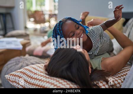 Une mère et une fille joueuses sur le canapé du salon Banque D'Images