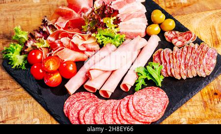 Tranches de délicieux salami à la saucisse espagnole.Divers types de viande et de saucisses sur une table en bois.concept alimentaire sain.viandes et saucisses variées Banque D'Images