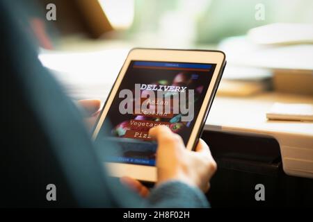 Femme regardant le menu à emporter sur une tablette numérique Banque D'Images