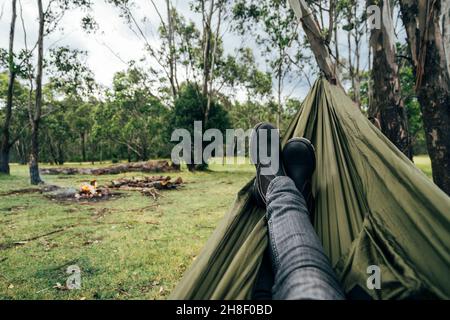 Homme de POV se détendant avec les pieds au camping, Australie Banque D'Images