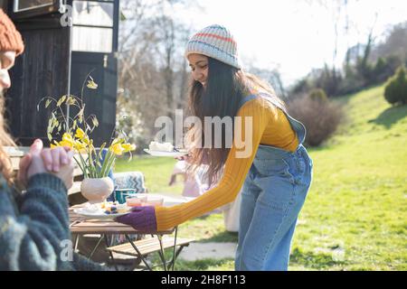 Bonne jeune femme avec petit déjeuner au camping ensoleillé Banque D'Images