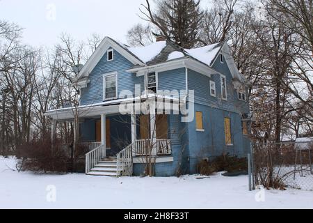 Abandonné et monté à bord d'une maison aux panneaux bleus à Flint, Michigan, en hiver Banque D'Images