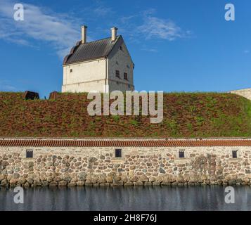 Vadstena, Suède - 23 mai 2021 : une partie du mur autour du château avec une végétation sur le toit et la tour derrière Banque D'Images