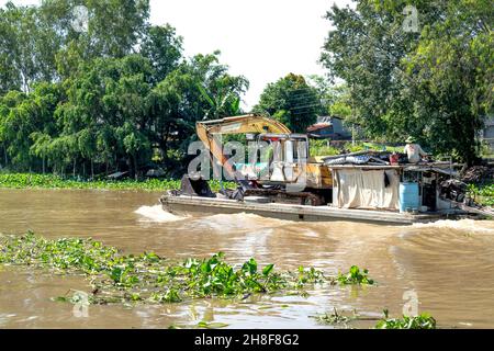 District de MOC Hoa, province de Tay Ninh, Vietnam - 23 novembre 2021 : un camion de pelle hydraulique se déplace par barge sur une rivière dans la province de Tay Ninh, Vietnam Banque D'Images
