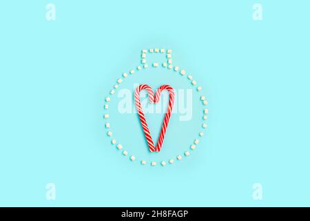 Canne en sucre en forme de coeur et guimauve comme un jouet rond de noël.Pose à plat.Concept de vacances. Banque D'Images